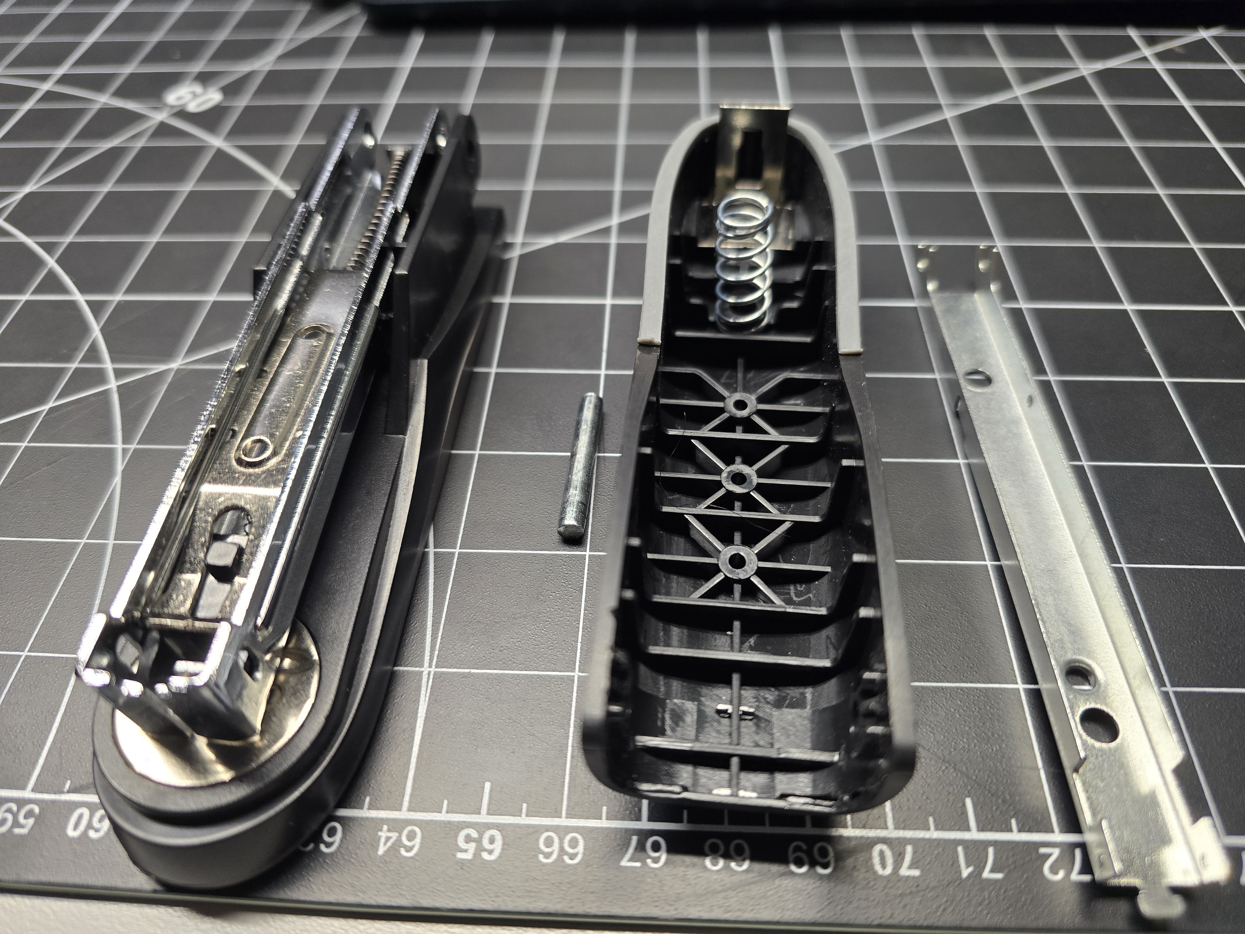 Stapler disassembled showing metal carriage and plastic body